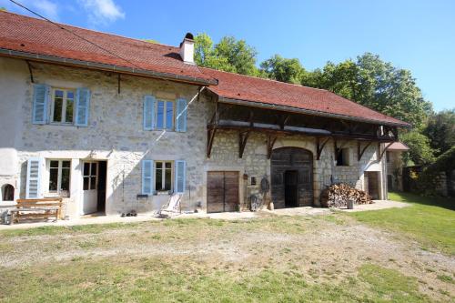 an old stone house with a red roof at Chambres d'hôtes des Deux Lacs in Ceyzérieu