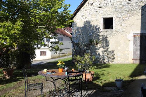 a table and chairs in a yard next to a building at Chambres d'hôtes des Deux Lacs in Ceyzérieu