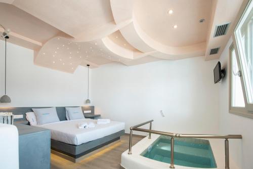 a room with a bed and a bath tub at Villa Galinia in Akrotiri