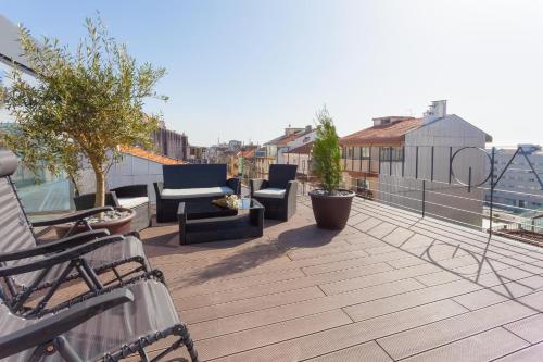 a balcony with chairs and furniture on a roof at URBAN VIEWS Terrace - Duplex Apartment "Maria Pia" in Porto