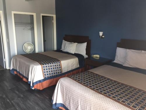 皮斯莫比奇的住宿－海濱花園汽車旅館，两张位于酒店客房的床,拥有蓝色的墙壁