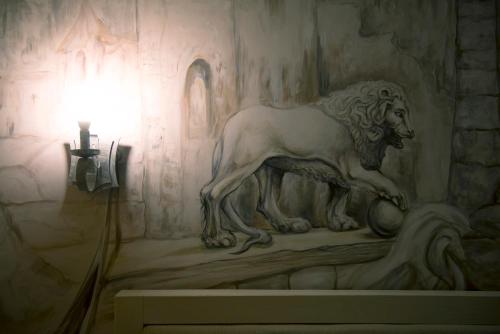 a statue of a lion on a wall next to a light at Aparthotel NA DOBU in Lviv