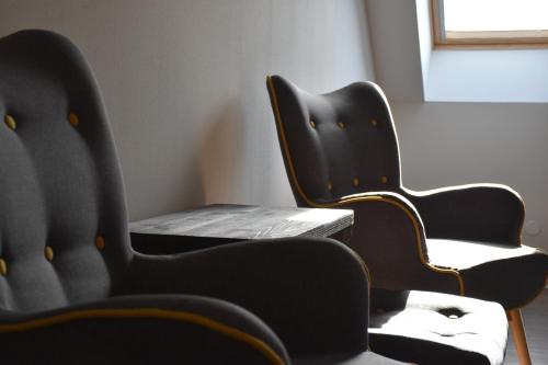 two black chairs and a table in a room at Penzion Víno Hruška Blatnička in Blatnička