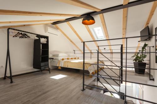 una camera da letto soppalcata con letto e scala a chiocciola di Apartments Stube 4 a Rovigno (Rovinj)