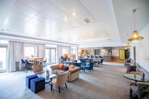 a living room with a couch and chairs and tables at Denham Grove in Denham