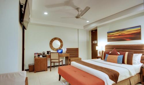 a bedroom with a large bed and a desk at The Somerset Hotel in Male City