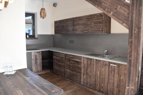 a kitchen with wooden cabinets and a sink at Penzion Víno Hruška Blatnička in Blatnička