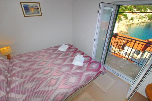 a bed in a room with a view of a balcony at Apartment Mambo in Sobra