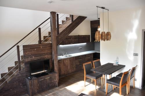 a dining room with a table and a staircase at Penzion Víno Hruška Blatnička in Blatnička