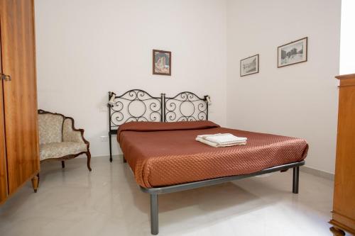 una camera con letto e sedia di Appartamento Piazza Pretoria a Palermo