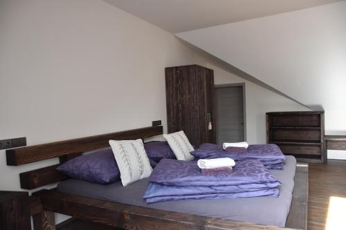a bedroom with two beds with purple sheets at Penzion Víno Hruška Blatnička in Blatnička