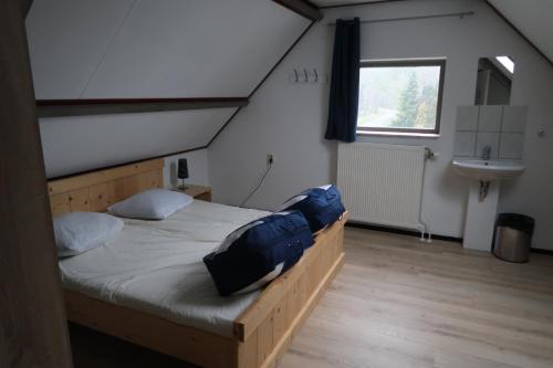 sypialnia z łóżkiem i umywalką na poddaszu w obiekcie loonse huis w mieście Loon op Zand