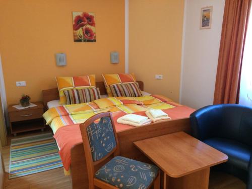 a small bedroom with a bed and a chair at Apartments and Rooms Tavcar in Bled