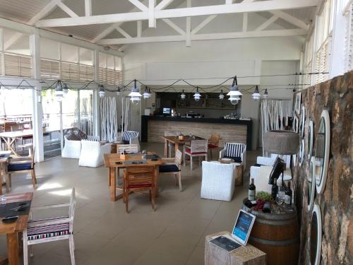a large room with tables and chairs and a dining room at Azuri Appartements De Luxe in Roches Noires