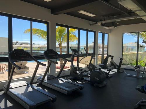 a gym with cardio machines and a view of the beach at Azuri Appartements De Luxe in Roches Noires