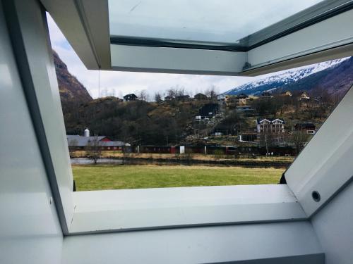 a window in a house with a view of a grassy field at Brekke Apartments in Flåm