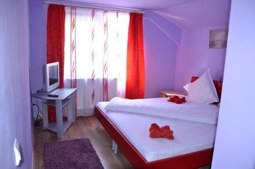 a small room with two beds and a television at Cabana Plapumioara in Eşelniţa