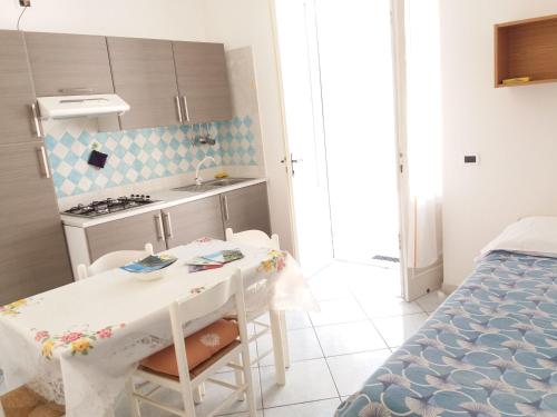 una pequeña cocina con mesa y sillas en una habitación en GRomano Apartments, en Isquia