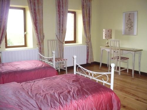 1 dormitorio con 2 camas, mesa y sillas en Les Convertigues, en Montjoire