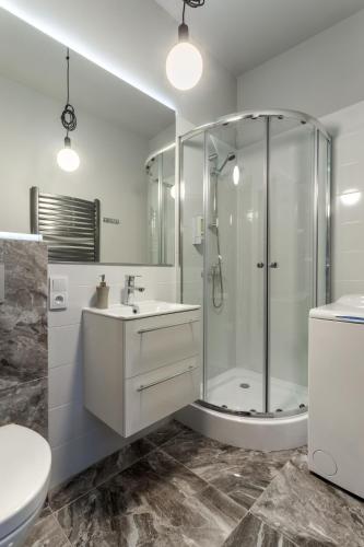 a bathroom with a shower and a sink and a toilet at Apartamenty Centrum Częstochowa Stara Kamienica in Częstochowa