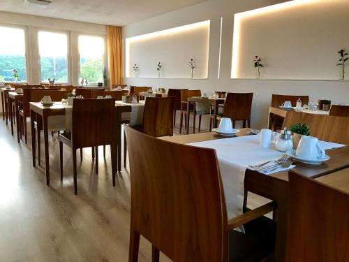 a dining room with tables and chairs and windows at Hotel Panorama in Niederfüllbach