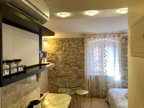 a room with a bed and a table and a window at Apartments Feral in Trogir