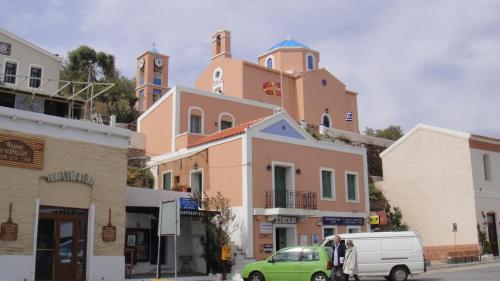a small green van parked in front of a building at The house in the port in Korissia