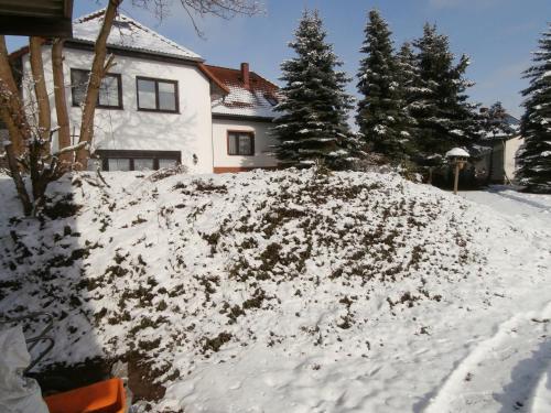 a pile of snow in front of a house at Gästehaus Pension Heß - Das kleine Hotel in Güstrow
