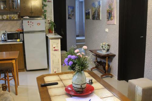 a kitchen with a vase of flowers on a table at Guest house poligloti in Tʼelavi