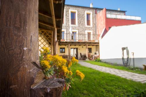 a house with yellow flowers on the side of a pole at La Casona de Sarria in Sarria