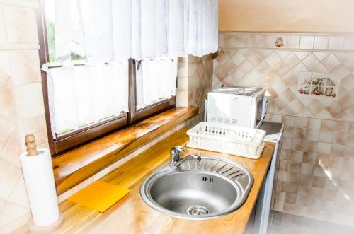 eine Küche mit einem Waschbecken und einem Fenster in der Unterkunft Domek nad Szelągiem in Kątno