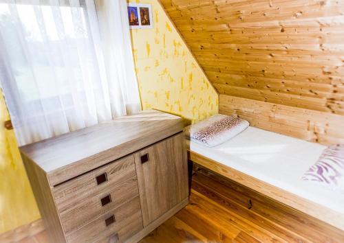 a wooden cabin with two beds in a room at Domek nad Szelągiem in Kątno