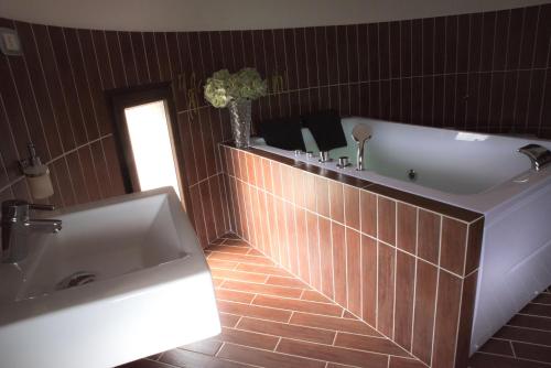 a bathroom with a large tub and a sink at Il Castello in Piazza Armerina