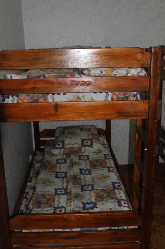 a wooden bunk bed with a comforter on it at Old Tiraspol Hostel in Tiraspol