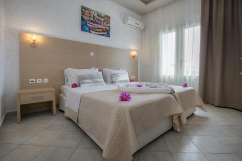 a hotel room with two beds with pink flowers on them at Castello in Limenaria