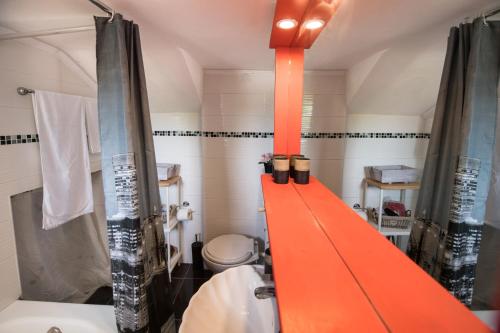an orange shelf in a bathroom with a toilet and a sink at La casa di Iro in Lefkada