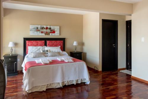 1 dormitorio con 1 cama grande y cabecero rojo en Anamar en Salta