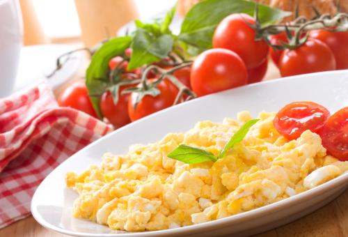 a plate of scrambled eggs with tomatoes on a table at Newland Wójtowicz in Debrznica