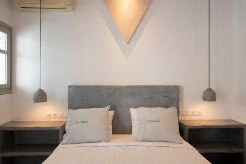 a bedroom with a bed with two pillows and two tables at Villa Galinia in Akrotiri