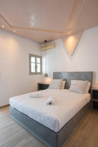 a bedroom with a large bed with white sheets at Villa Galinia in Akrotiri