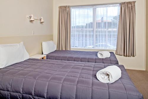 a hotel room with two beds and a window at Tourist Court Motel in Whakatane