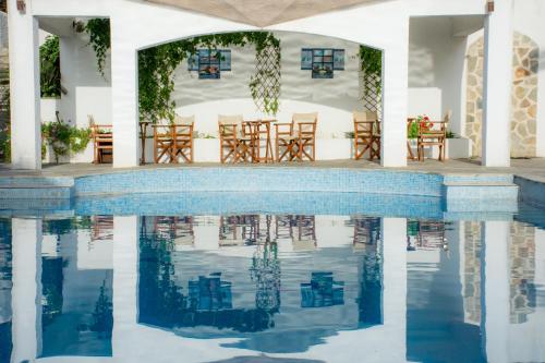 a pool with chairs and tables next to a house at Seralis Pelion in Afissos