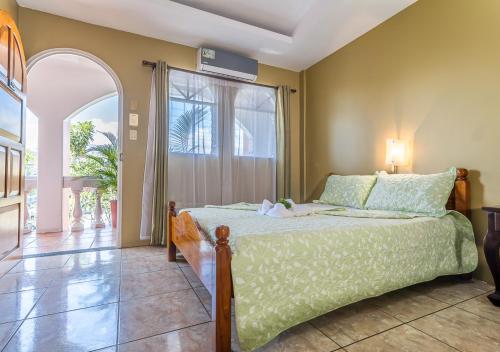 a bedroom with a bed and a large window at Hotel Le Priss in Manuel Antonio