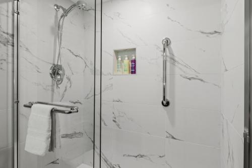 a bathroom with a shower with a glass door at Best Western Premier Calgary Plaza Hotel & Conference Centre in Calgary