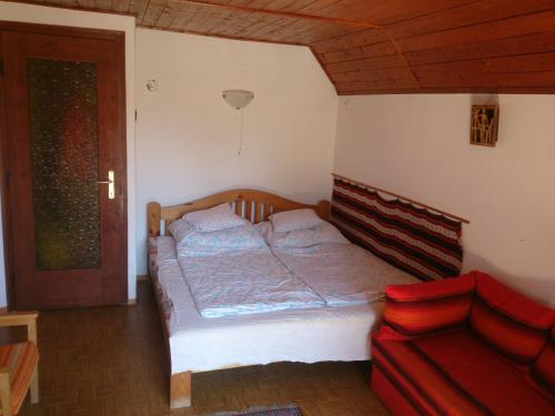 バラトンセメッシュにあるBalatonszemes Nyaralóのベッドルーム1室(ベッド1台、赤いソファ付)