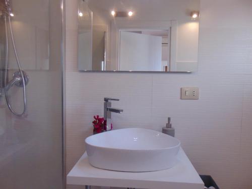 a white bathroom with a sink and a mirror at Appartamenti in Villa Nicanda in Porto Columbu - Perdʼe Sali
