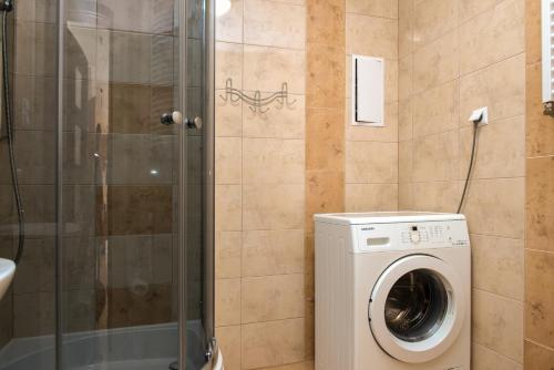 a bathroom with a washing machine and a shower at Apartament Grażyna in Giżycko