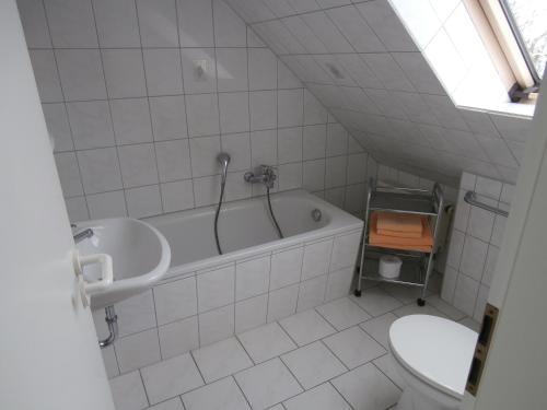 a bathroom with a sink and a tub and a toilet at Gästehaus Pension Heß - Das kleine Hotel in Güstrow