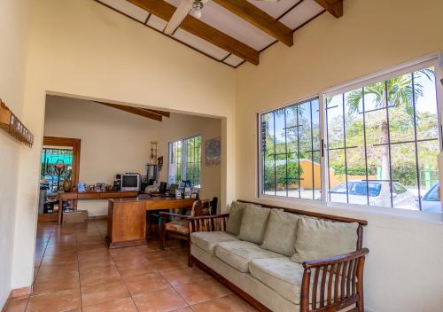 a living room with a couch and a table at Hotel Guanacaste Lodge in Playa Flamingo