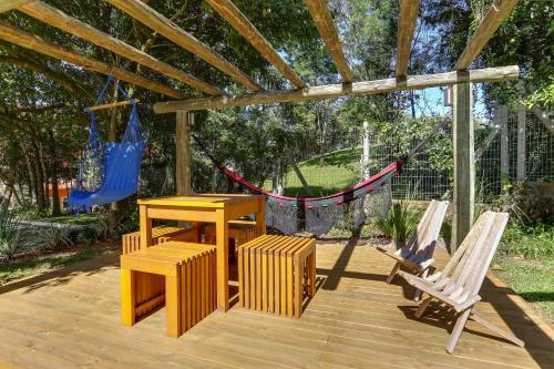 a patio with a table and chairs and a hammock at Vila Rica Pousada in Nova Petrópolis